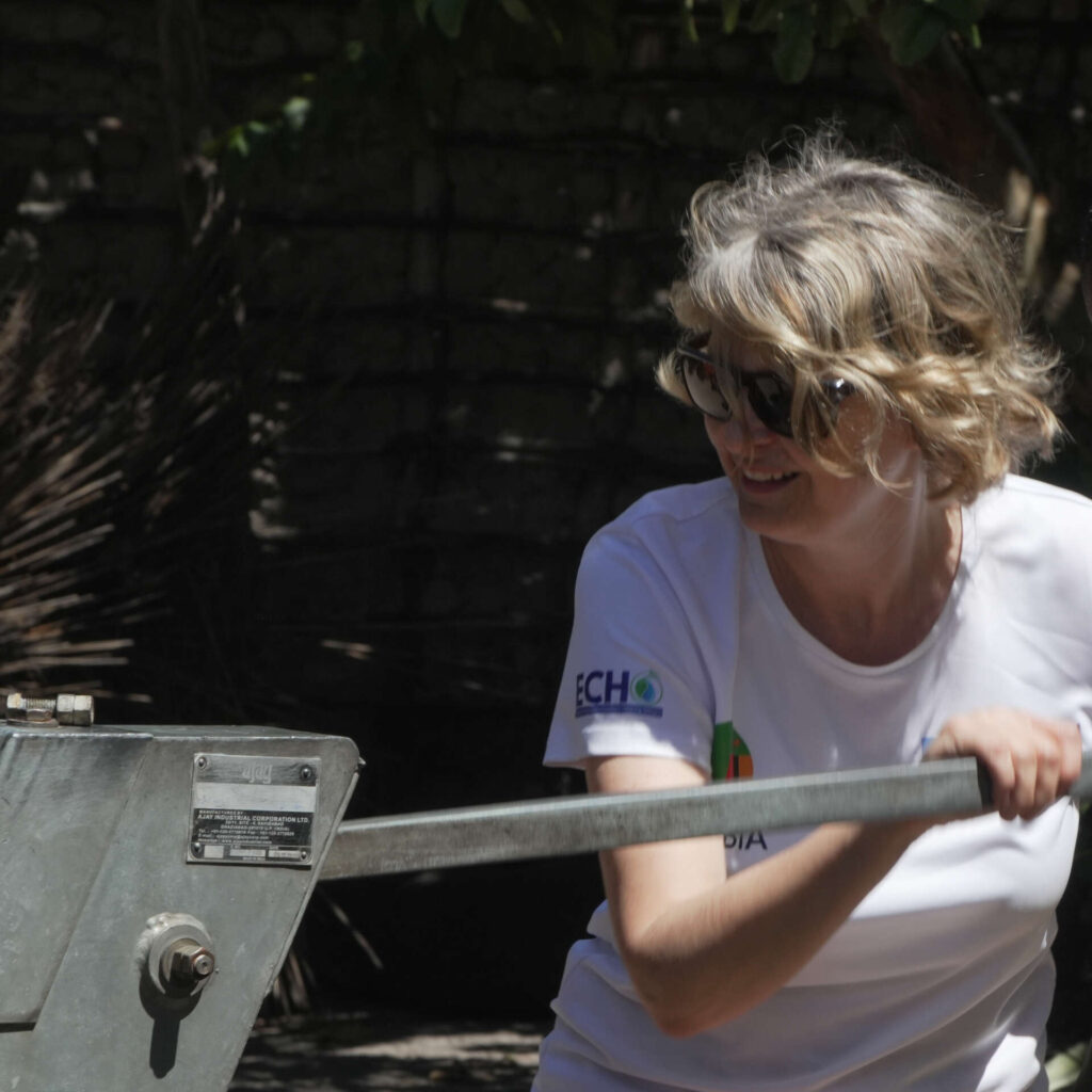 Rachel Poole smiling while pumping a borehole during a community project in Zambia